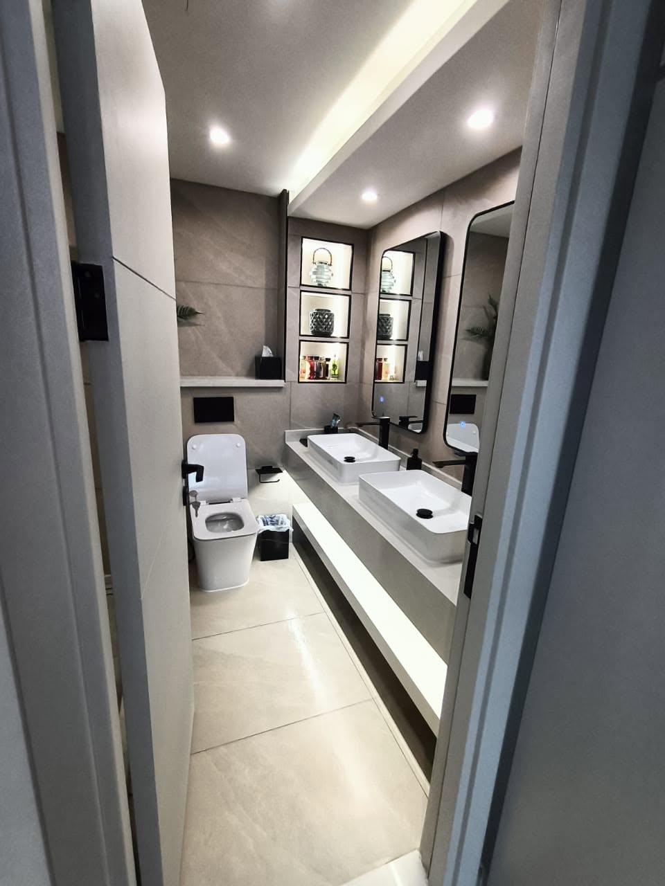 Finished bathroom with a lit mirror